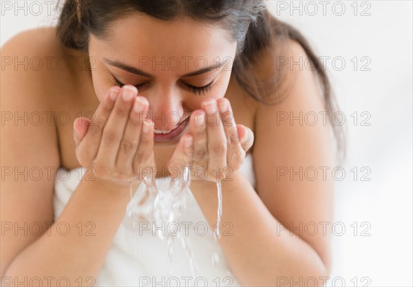 Close up of Asian woman washing face