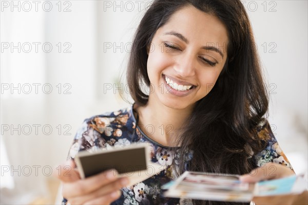 Smiling Asian woman looking at photographs