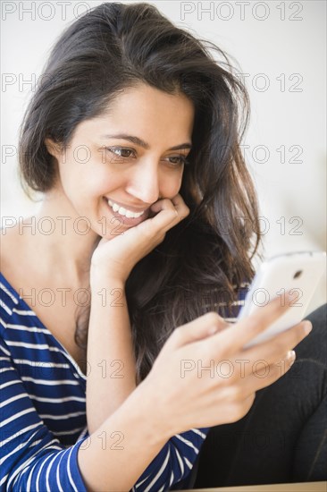 Close up of Asian woman text messaging with cell phone