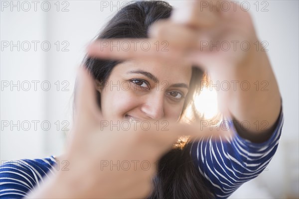 Close up portrait of Asian woman making finger frame