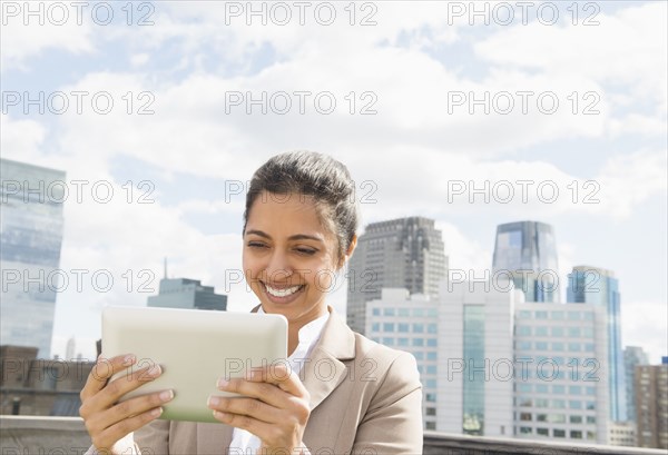 Asian businesswoman using digital tablet on urban balcony