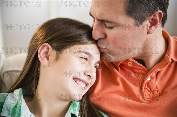 Caucasian father kissing daughter's forehead