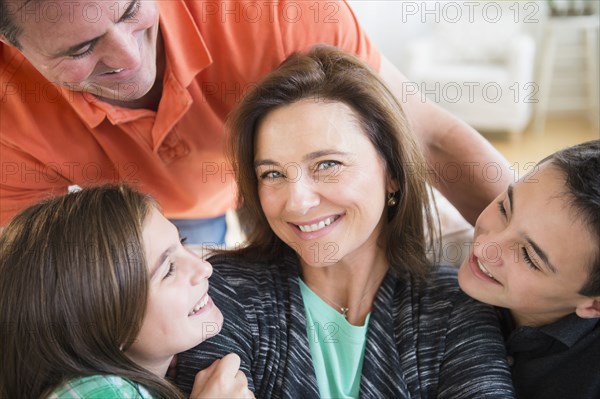 Caucasian man and children smiling at woman