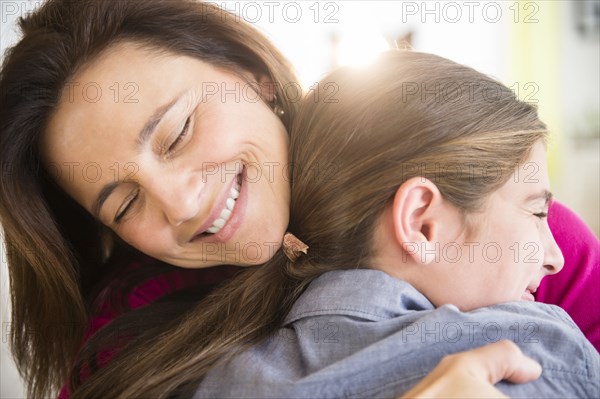 Close up of Caucasian mother and daughter hugging