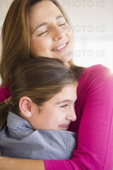 Close up of Caucasian mother and daughter hugging