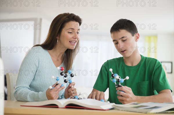 Caucasian mother and son studying atom models