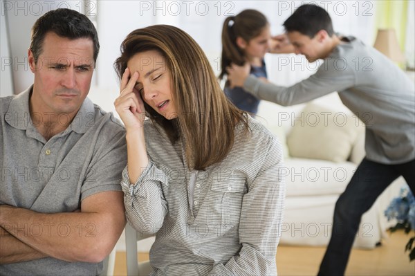 Frustrated Caucasian parents listening to children fight