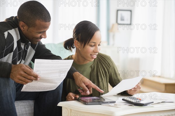 Couple paying bills in living room