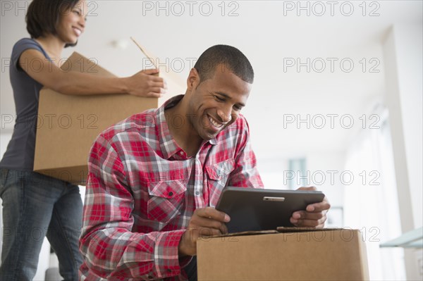 Couple with digital tablet and moving boxes