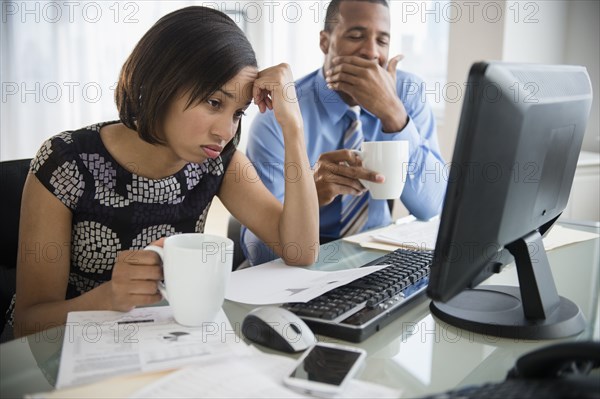 Exhausted business people with coffee working at computer