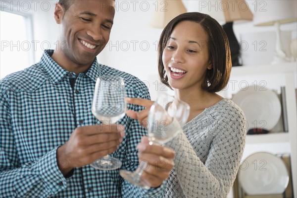 Happy couple shopping for wine glasses