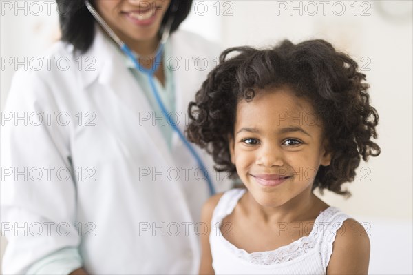 Portrait of smiling African American girl with doctor