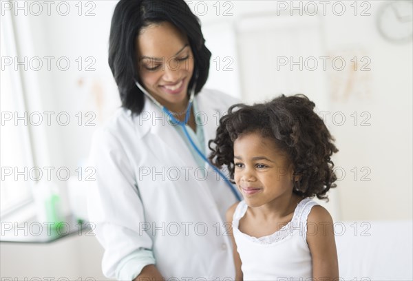 African American girl receiving checkup from doctor