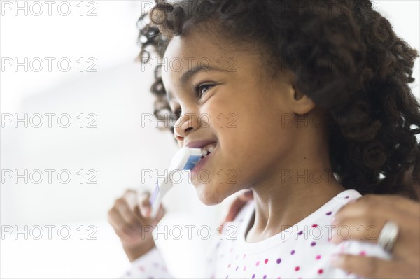 Close up of African American girl brushing teeth