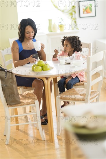 African American mother and daughter at breakfast table