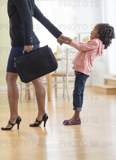 Black mother pulling anxious daughter