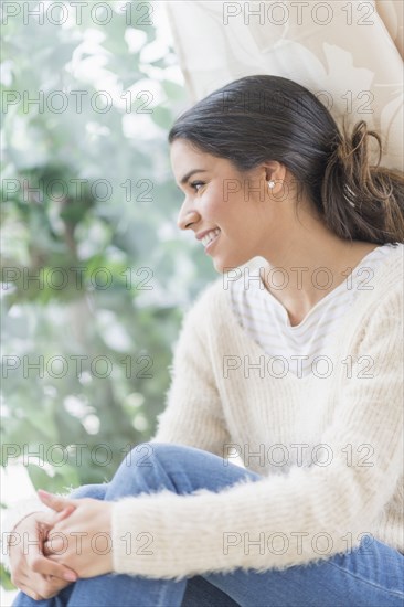 Smiling Hispanic woman looking out window