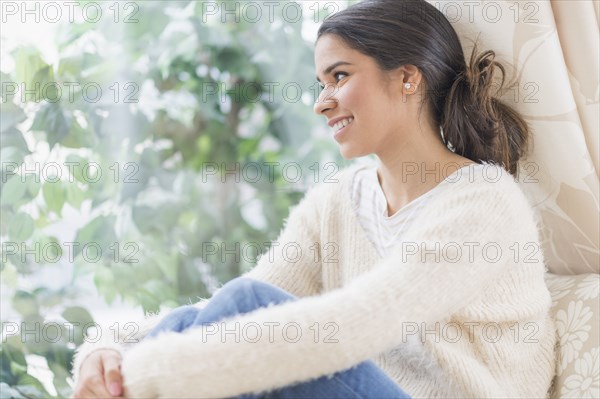 Smiling Hispanic woman looking out window