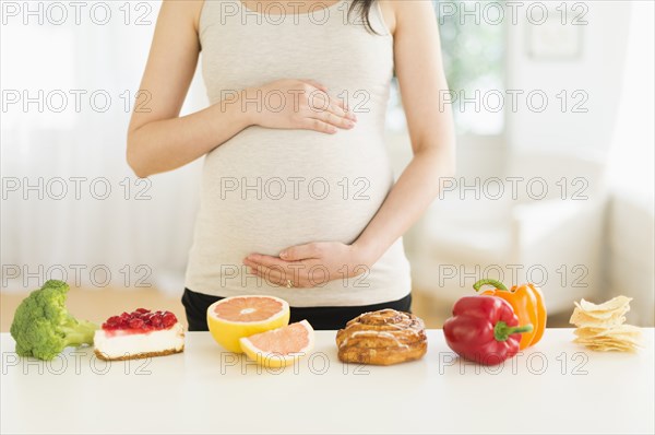 Health and unhealthy foods in front of pregnant Japanese woman