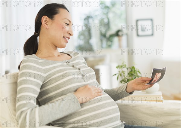 Pregnant Japanese woman looking at ultrasound image