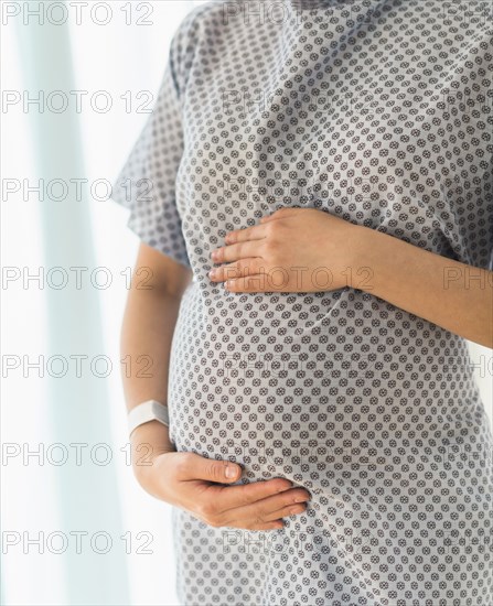 Close up of pregnant Japanese woman in hospital gown