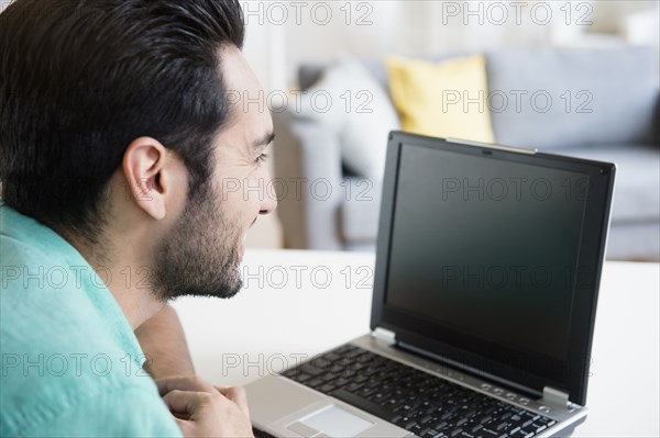 Mixed race man using laptop