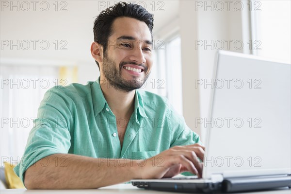 Mixed race man using laptop