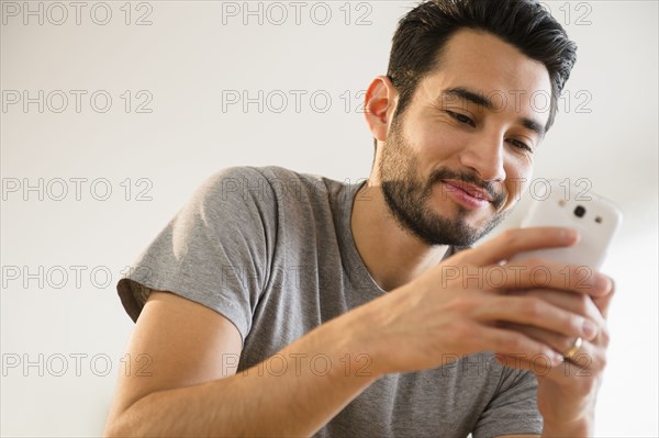 Mixed race man using cell phone