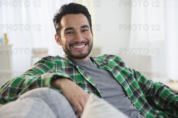 Mixed race man smiling on sofa