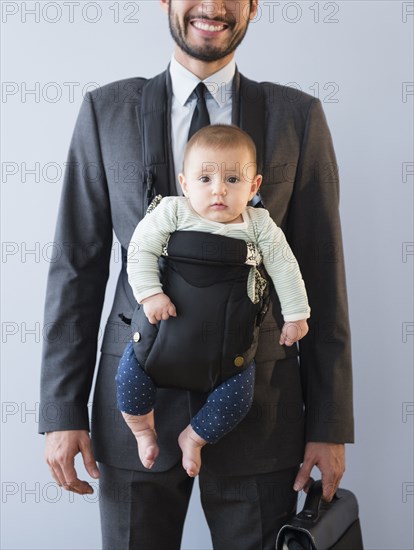 Businessman carrying baby in carrier