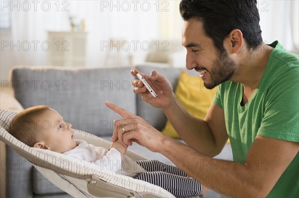 Father taking pictures of baby