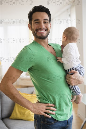 Father holding baby in living room