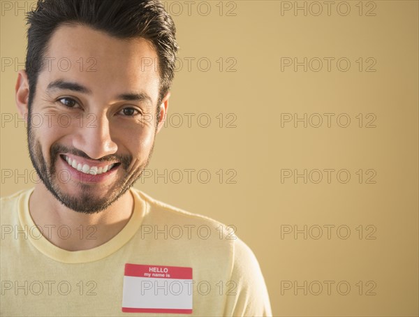 Mixed race man wearing name tag