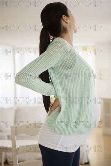 Pregnant Caucasian woman stretching her back