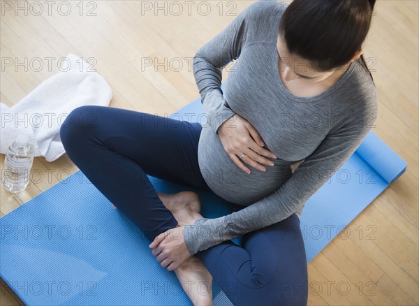 Pregnant Caucasian woman practicing yoga