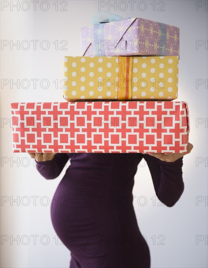 Pregnant Caucasian woman holding wrapped gifts