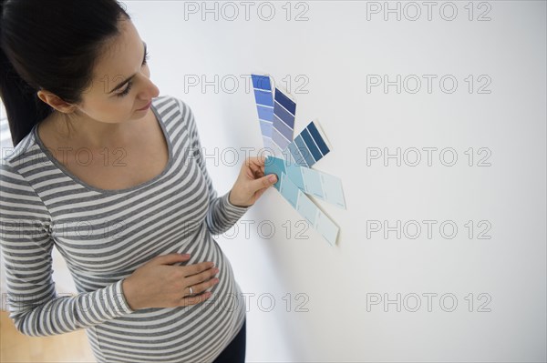 Pregnant Caucasian woman examining paint swatches