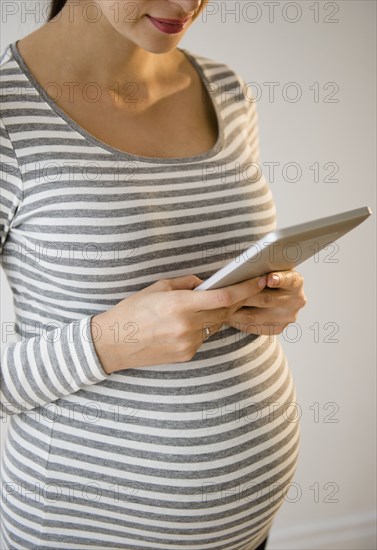 Pregnant Caucasian woman using digital tablet