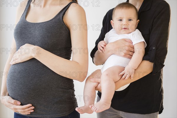 Pregnant Caucasian woman with friend and baby