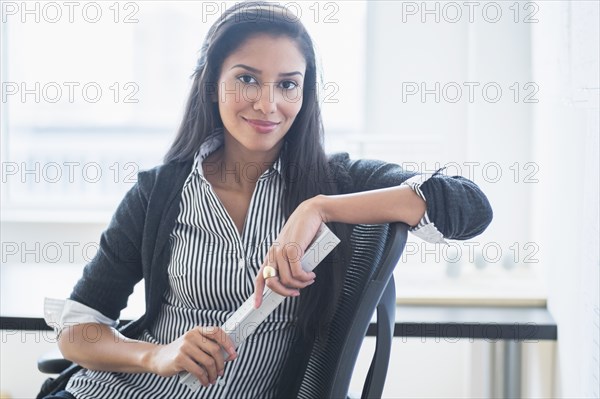 Hispanic businesswoman smiling in office