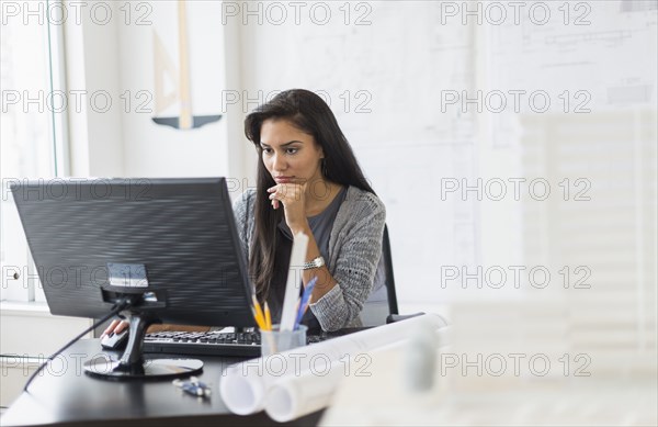 Hispanic businesswoman working in office