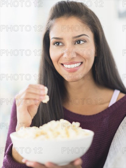Hispanic woman eating popcorn