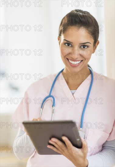 Hispanic nurse using digital tablet in hospital