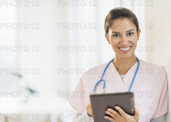 Hispanic nurse using digital tablet in hospital