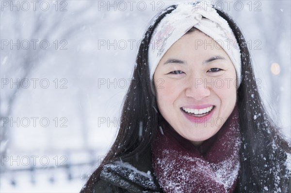 Asian woman smiling in snow