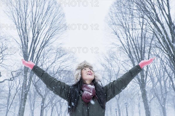 Asian woman cheering in snowy park