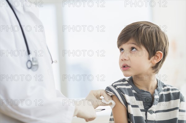 Hispanic boy getting a shot at doctor's office