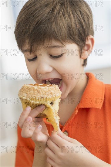 Hispanic boy eating muffin