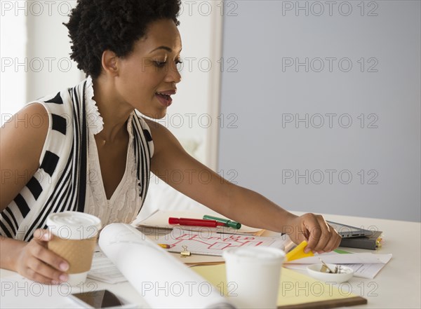 Black businesswoman drinking coffee and working