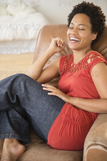 Black woman laughing in armchair